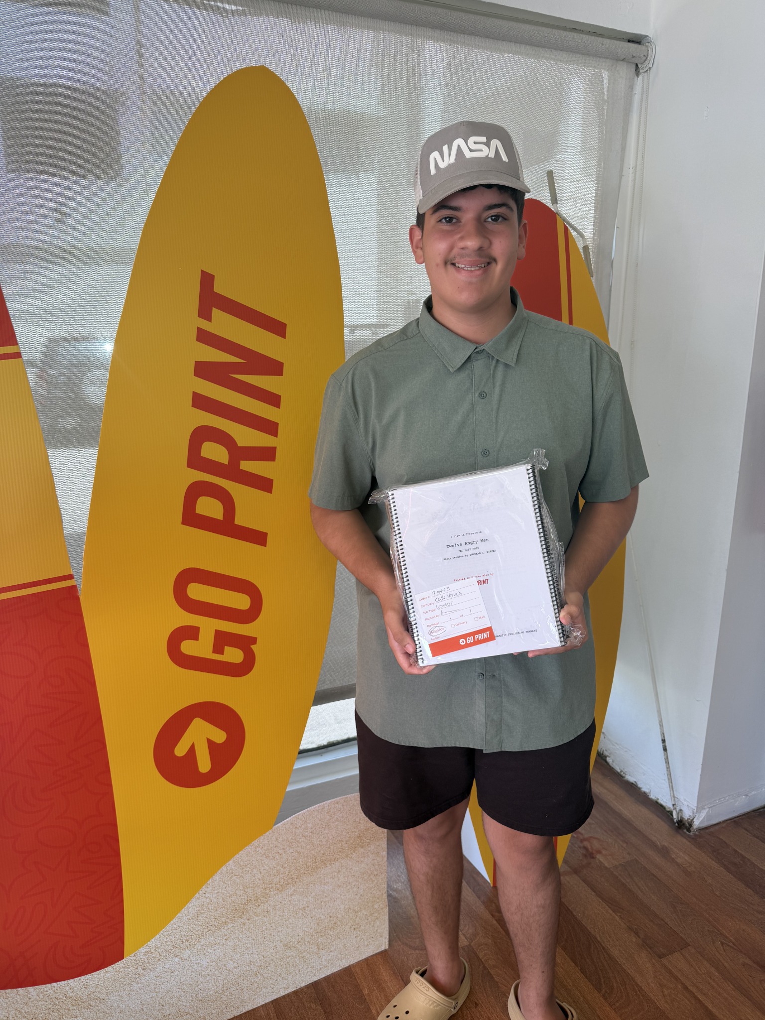 Jean Ortiz sosteniendo los libretos impresos por Go Print